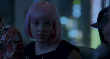 Movie still from “Lost in Translation” (2003), directed by Sofia Coppola – A woman with pink hair sitting in front of a blurry background; Close Up shot, Over the shoulder angle