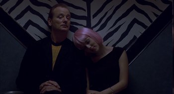 Movie still from “Lost in Translation” (2003), directed by Sofia Coppola – A man and a woman with their heads resting on each other; Medium shot, Low angle