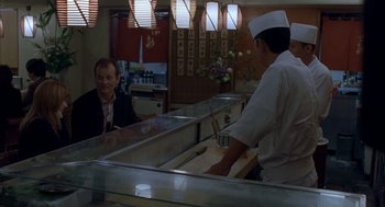 Movie still from “Lost in Translation” (2003), directed by Sofia Coppola – A man in a chef's hat is standing in front of a man in a suit; Medium shot, Over the shoulder angle