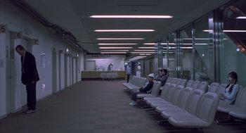 Movie still from “Lost in Translation” (2003), directed by Sofia Coppola – People sitting in a waiting area of an airport; Extreme Wide shot, High angle