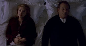 Movie still from “Lost in Translation” (2003), directed by Sofia Coppola – A man and a woman laying in bed next to each other; Medium shot, Overhead angle