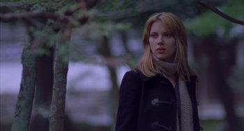 Movie still from “Lost in Translation” (2003), directed by Sofia Coppola – A beautiful young lady wearing a black coat and a scarf; Medium shot, Low angle