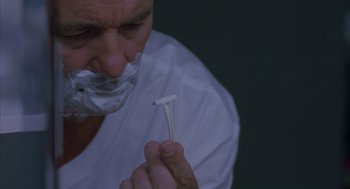Movie still from “Lost in Translation” (2003), directed by Sofia Coppola – A man with a shaving razor in his mouth; Extreme Close Up shot, Overhead angle