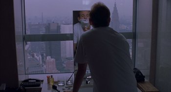Movie still from “Lost in Translation” (2003), directed by Sofia Coppola – A man is looking in the mirror while shaving his face; Medium shot, Over the shoulder angle