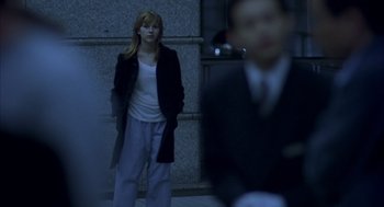 Movie still from “Lost in Translation” (2003), directed by Sofia Coppola – A woman standing on the sidewalk in front of a building; Medium shot, Over the shoulder angle