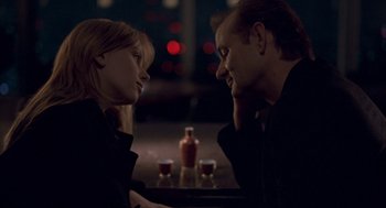 Movie still from “Lost in Translation” (2003), directed by Sofia Coppola – A man and a woman sitting in front of each other at a table; Close Up shot, Over the shoulder angle
