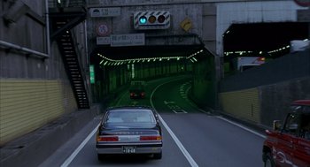 Movie still from “Lost in Translation” (2003), directed by Sofia Coppola – A car driving down a street under an overpass; Wide shot, High angle
