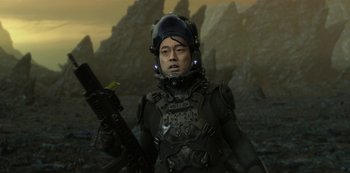 Movie still from “Love, Death & Robots” (2019), created by Tim Miller – A man in a helmet holding a rifle in front of mountains; Medium shot, Over the shoulder angle