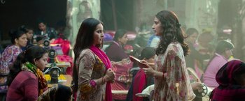 Two young women are talking in a room