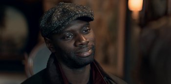 Movie still from “Lupin” (2021), created by Tigran Rosine – A person wearing a hat; Close Up shot, High angle