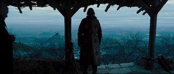 Movie still from “Kingdom of Heaven” (2005), directed by Ridley Scott – A man in a robe standing on top of a hill; Wide shot, Low angle