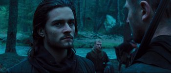 Movie still from “Kingdom of Heaven” (2005), directed by Ridley Scott – A man with long black hair and blue eyes in the woods; Close Up shot, Low angle