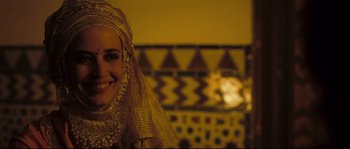 Movie still from “Kingdom of Heaven” (2005), directed by Ridley Scott – A woman wearing a gold headscarf smiling for the camera; Close Up shot, Over the shoulder angle