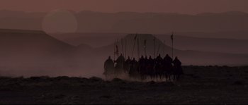 Movie still from “Kingdom of Heaven” (2005), directed by Ridley Scott – A group of people riding on horseback across a field at night; Extreme Wide shot, Low angle