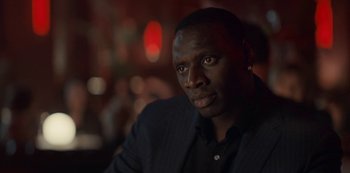 Movie still from “Lupin” (2021), created by Tigran Rosine – A person wearing a suit; Close Up shot, Over the shoulder angle