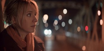 Movie still from “Lupin” (2021), created by Tigran Rosine – A woman is standing in the street at night; Close Up shot, Over the shoulder angle