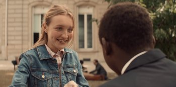 Movie still from “Lupin” (2021), created by Tigran Rosine – A young woman and a young man talking to each other; Close Up shot, Over the shoulder angle