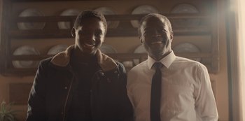 Movie still from “Lupin” (2021), created by Tigran Rosine – A man standing next to a woman in a room; Close Up shot, Over the shoulder angle