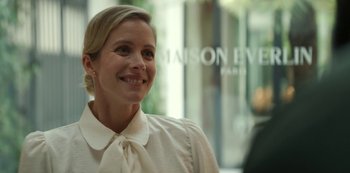 Movie still from “Lupin” (2021), created by Tigran Rosine – A woman wearing a white shirt and a white bow tie; Close Up shot, Low angle