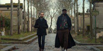 Movie still from “Lupin” (2021), created by Tigran Rosine – A couple of men walking down a street; Medium shot, Low angle