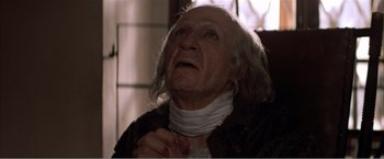 Movie still from “Amadeus” (1984), directed by Milos Forman – An old man wearing a neck scarf looking up; Close Up shot, Low angle