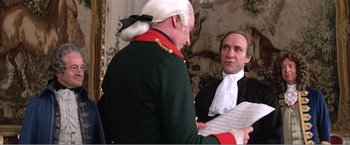 Movie still from “Amadeus” (1984), directed by Milos Forman – Two men in historical costumes talking to each other; Medium shot, Over the shoulder angle