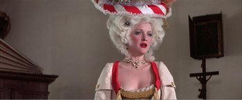 Movie still from “Amadeus” (1984), directed by Milos Forman – A woman in a wig and a red and white hat; Medium shot, Low angle