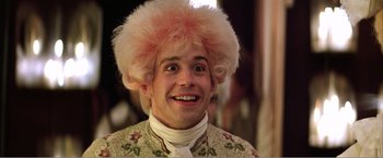 Movie still from “Amadeus” (1984), directed by Milos Forman – A man in a pink wig and a floral shirt; Close Up shot, Over the shoulder angle