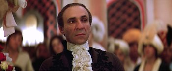 Movie still from “Amadeus” (1984), directed by Milos Forman – A person wearing a suit and tie; Close Up shot, Low angle