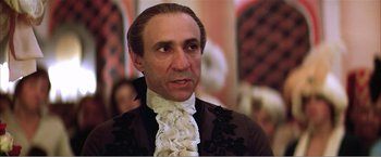 Movie still from “Amadeus” (1984), directed by Milos Forman – A person wearing a suit and tie; Close Up shot, Low angle