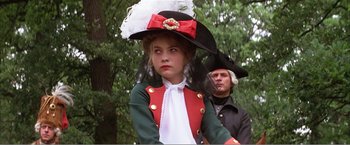 Movie still from “Amadeus” (1984), directed by Milos Forman – A young girl in a red , white , and green costume; Medium shot, Low angle