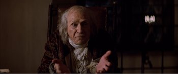 Movie still from “Amadeus” (1984), directed by Milos Forman – An old man in a wig and a jacket; Close Up shot, High angle