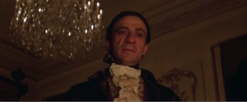 Movie still from “Amadeus” (1984), directed by Milos Forman – A person wearing a suit and tie; Close Up shot, Low angle