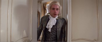 Movie still from “Amadeus” (1984), directed by Milos Forman – A man in a wig and a wig stand next to a mirror; Medium shot, Over the shoulder angle