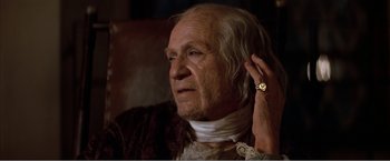 Movie still from “Amadeus” (1984), directed by Milos Forman – An old man with a beard and a ring on his ear; Close Up shot, Over the shoulder angle