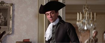 Movie still from “Amadeus” (1984), directed by Milos Forman – A man wearing a black hat and a black and white suit; Medium shot, Low angle