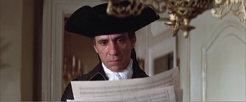 Movie still from “Amadeus” (1984), directed by Milos Forman – A man wearing a pirate hat looking at a sheet of music; Close Up shot, Low angle