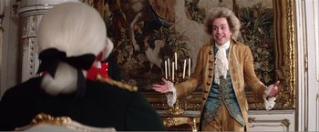 Movie still from “Amadeus” (1984), directed by Milos Forman – A man dressed in period clothing and wig talking to another man in period garb; Medium shot, Over the shoulder angle