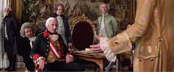 Movie still from “Amadeus” (1984), directed by Milos Forman – A group of men dressed in period clothing; Medium shot, Over the shoulder angle