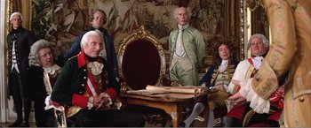 Movie still from “Amadeus” (1984), directed by Milos Forman – A group of men sitting in front of a wooden table; Medium shot, High angle