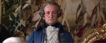 Movie still from “Amadeus” (1984), directed by Milos Forman – A man in a wig and a blue jacket; Close Up shot, Low angle