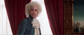 Movie still from “Amadeus” (1984), directed by Milos Forman – A man in a wig and a wig stand in front of a window; Close Up shot, Over the shoulder angle