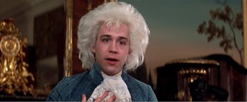 Movie still from “Amadeus” (1984), directed by Milos Forman – A man with a white wig and blue eyes wearing a wig; Close Up shot, Over the shoulder angle