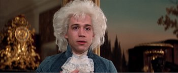 Movie still from “Amadeus” (1984), directed by Milos Forman – A man in a wig is looking at the camera; Close Up shot, Low angle