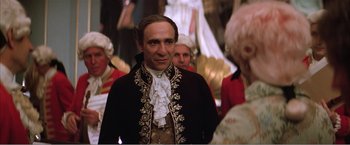 Movie still from “Amadeus” (1984), directed by Milos Forman – A man in a black and gold outfit standing in front of a crowd; Medium shot, Over the shoulder angle