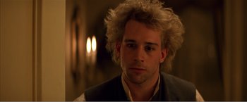 Movie still from “Amadeus” (1984), directed by Milos Forman – A young man with blonde curly hair wearing a vest; Close Up shot, Low angle