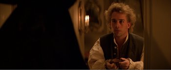 Movie still from “Amadeus” (1984), directed by Milos Forman – A young man in a medieval garb sitting in front of a mirror; Close Up shot, Over the shoulder angle