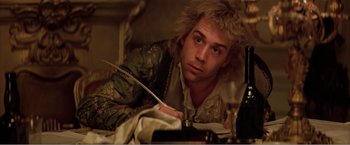 Movie still from “Amadeus” (1984), directed by Milos Forman – A young man is sitting in a bed writing; Close Up shot, High angle