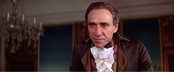 Movie still from “Amadeus” (1984), directed by Milos Forman – A person wearing a suit and tie; Close Up shot, Low angle