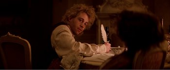 Movie still from “Amadeus” (1984), directed by Milos Forman – A man sitting at a table writing with a feather pen; Close Up shot, Low angle
